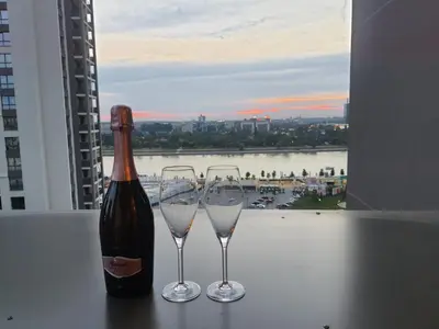 a bottle of wine and two wine glasses on a table at Belgrade Waterfront Lux Apartment in Belgrade