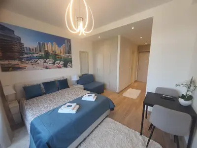 a bedroom with a blue bed and a desk at Belgrade Waterfront Lux Apartment in Belgrade