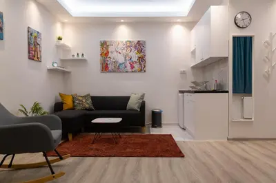 a living room with a couch and a kitchen at Fair Apartment in Belgrade