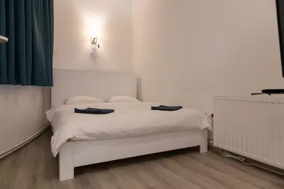 a bedroom with a white bed with two towels on it at Fair Apartment in Belgrade