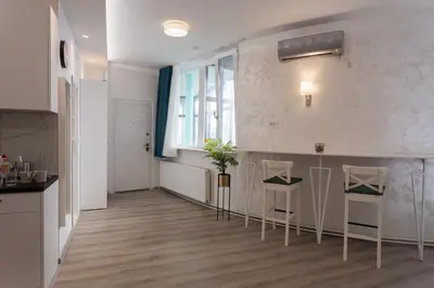 a kitchen with two chairs and a table in a room at Fair Apartment in Belgrade