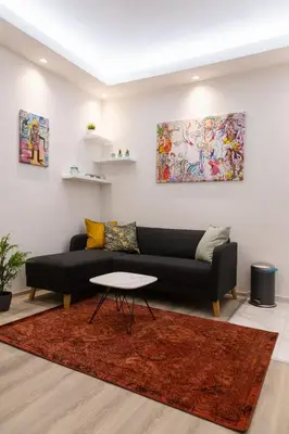 a living room with a black couch and a table at Fair Apartment in Belgrade