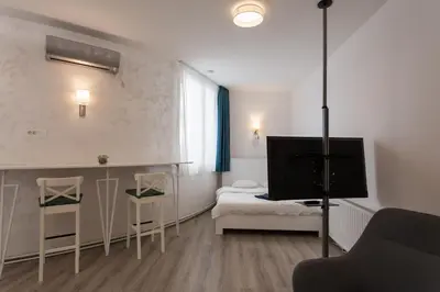 a living room with a tv and a couch and a bed at Fair Apartment in Belgrade