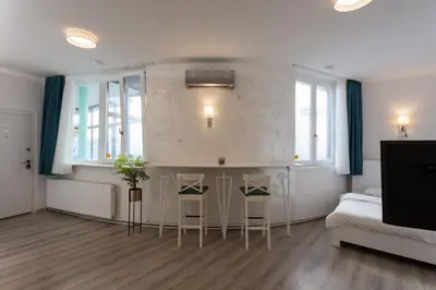 a bedroom with a bed and two stools at Fair Apartment in Belgrade