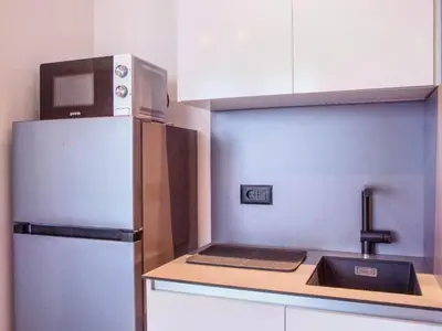 a kitchen with a refrigerator and a laptop on a counter at Metropolitan Apartman - City View in Belgrade