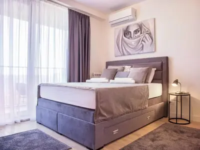 a bedroom with a large bed in front of a window at Metropolitan Apartman - City View in Belgrade