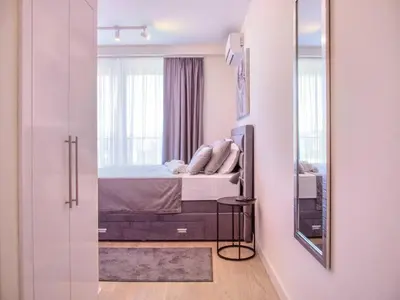 a bedroom with a bed and a mirror at Metropolitan Apartman - City View in Belgrade