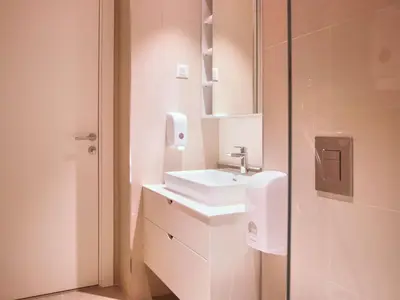 a white bathroom with a sink and a mirror at Metropolitan Apartman - City View in Belgrade