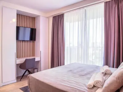 a hotel room with a bed and a large window at Metropolitan Apartman - City View in Belgrade