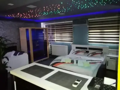 a room with a bed and a desk and a room with stars at Spa Apartment in Belgrade