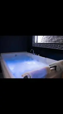 a bath tub with a white floor in a bathroom at Spa Apartment in Belgrade