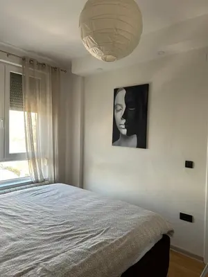a bedroom with a bed and a picture of a woman at Apartman DM in Zvezdara
