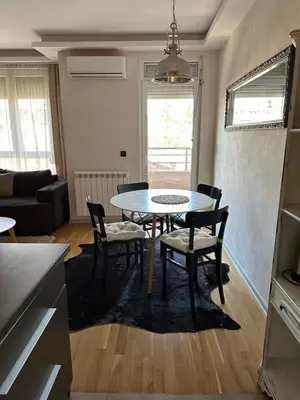 a kitchen and dining room with a table and chairs at Apartman DM in Zvezdara