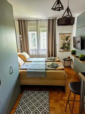 a small bedroom with a bed and a window at Studio Sunset in Voždovac
