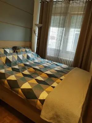 a bed with a colorful comforter in a bedroom at Studio Sunset in Voždovac
