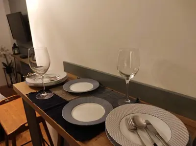 a table with plates and wine glasses on it at Studio Sunset in Voždovac