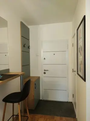a room with a door and a table and a stool at Studio Sunset in Voždovac