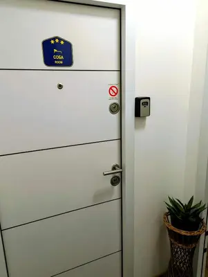 a door with a sign on it next to a plant at Studio Sunset in Voždovac