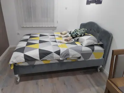 a bed with a teddy bear laying on it at Tid Apartman in Arandjelovac