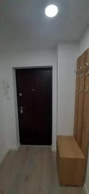 a room with a black door and a wooden bench at Tid Apartman in Arandjelovac