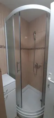a shower with a glass door in a bathroom at Tid Apartman in Arandjelovac