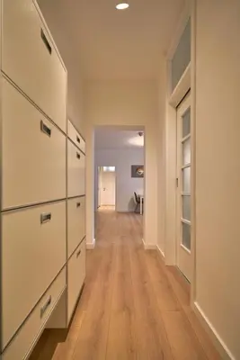 a hallway with white cabinets and a hard wood floor at Perfect 10 in Belgrade