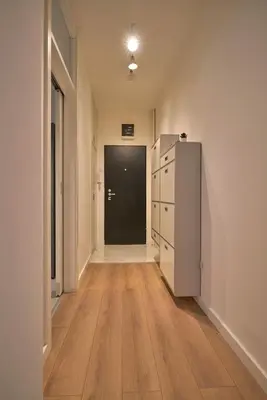 an empty hallway with a refrigerator and a black door at Perfect 10 in Belgrade