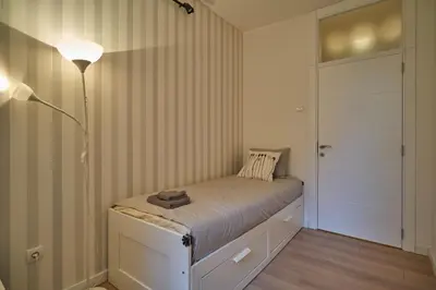 a small bedroom with a bed and a lamp at Perfect 10 in Belgrade