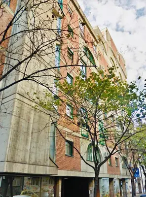 a tall brick building with a tree in front of it at Perfect 10 in Belgrade