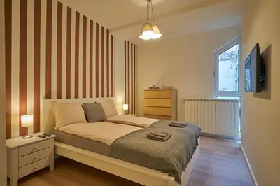 a bedroom with a bed and a tv on a wall at Perfect 10 in Belgrade