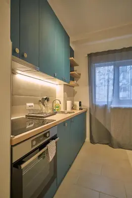 a kitchen with blue cabinets and a sink and a window at Perfect 10 in Belgrade