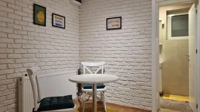 a table and chairs in a room with a brick wall at Apartments near Belgrade Waterfront in Belgrade