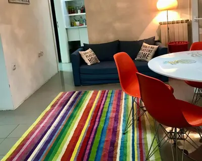 a living room with a couch and a colorful rug at Globetrotter's City Center Pied-à-Terre ᯤ in Belgrade