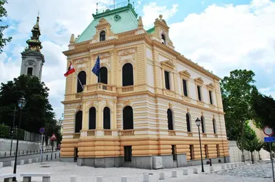 a large yellow building with a clock tower at Globetrotter's City Center Pied-à-Terre ᯤ in Belgrade