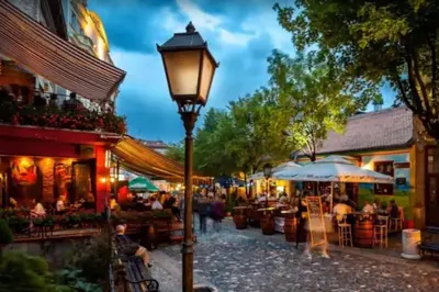 a street light in a city with people sitting at tables at Globetrotter's City Center Pied-à-Terre ᯤ in Belgrade