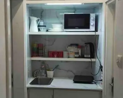 a kitchen cabinet with a sink and a microwave at Globetrotter's City Center Pied-à-Terre ᯤ in Belgrade