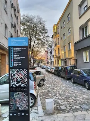 a sign on the side of a street with parked cars at Globetrotter's City Center Pied-à-Terre ᯤ in Belgrade