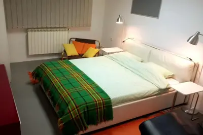 a bedroom with a bed with a green and yellow blanket at Globetrotter's City Center Modern ᯤ in Belgrade
