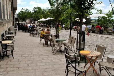 a group of people sitting at tables and chairs at Globetrotter's City Center Modern ᯤ in Belgrade