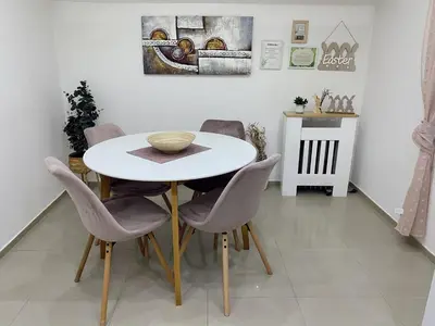 a dining room with a white table and chairs at Cozy Family House in Lazarevac