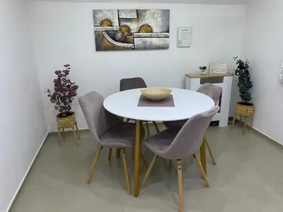 a dining room with a white table and chairs at Cozy Family House in Lazarevac