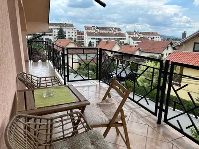 a balcony with a table and chairs and a view at Cozy Family House in Lazarevac