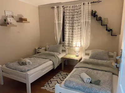 two twin beds in a room with a staircase at Cozy Family House in Lazarevac