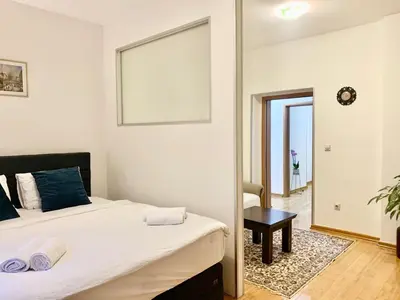 a bedroom with a bed and a table and a mirror at City Center Crown Apartment in Belgrade