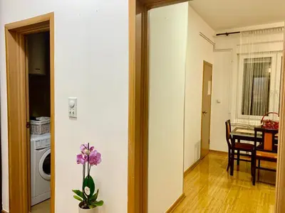 a living room with a table and a vase with purple flowers at City Center Crown Apartment in Belgrade