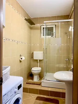 a bathroom with a toilet and a sink and a shower at City Center Crown Apartment in Belgrade