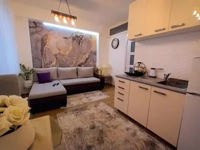 a living room with a couch and a kitchen at ODMORKO Zemun in Belgrade