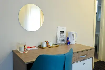 a desk with a blue chair and a mirror at Smeštaj Tank, Pančevo in Salaši