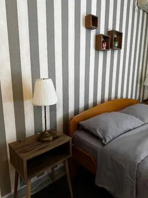 a bedroom with a bed and a table with a lamp at Holiday in Belgrade