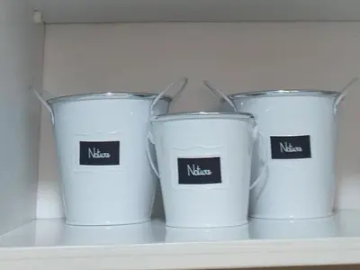 four white cups sitting on a shelf in a drawer at Apartman Marina Aranđelovac in Arandjelovac